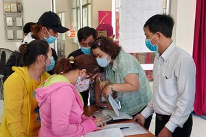 新平郡社保機關幹部（右）指引勞工辦理領取社保金手續。