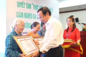 市委書記阮文年向在2016-2020年階段可持續扶貧計劃中 取得出色成績的家庭戶頒發獎狀。