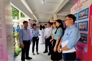 第五郡越南祖國陣線委員會主席黎晉才(左一)與各會館、代表參觀“胡志明文化空間”。