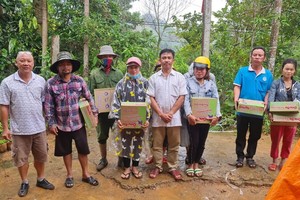 芽莊廣東會館理事長鄭成龍(左一)向災民贈送禮物。