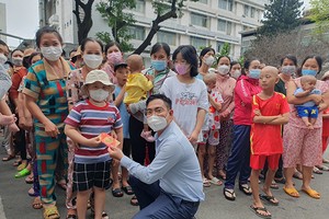 本报编委文忠孝向病童赠送红包。