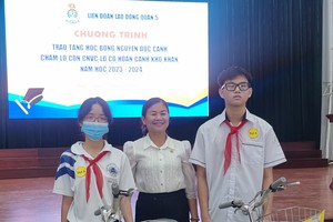 第五郡劳动联团主席黎氏碧幸向贫困优秀生赠送自行车。