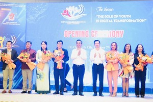 市委组织处主任阮福禄；共青团中央书记、越南大学生协会主席阮明哲向专家、科学家赠送鲜花。