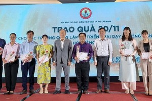 市民族处副主任曾福禄(右五)与陈家义先生(右七)向各校代表赠送鲜花和礼物祝贺。