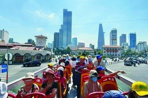 游客搭乘两层敞篷巴士游览本市。