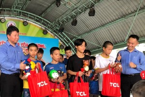 TCL智能电器有限公司代表向孤儿赠送礼物。