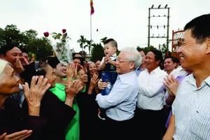 阮富仲总书记和海防市永保县荣光乡群众。图自越通社