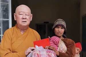 莲华寺住持释惟镇和尚向贫困者赠送礼物。