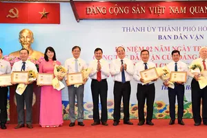 Phó Bí thư Thành ủy TPHCM Nguyễn Hồ Hải tặng kỷ niệm chương “Vì sự nghiệp dân vận”. Ảnh: VIỆT DŨNG