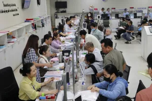 Cán bộ, công chức UBND quận 12 giải quyết hồ sơ cho người dân