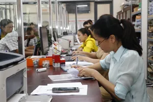 Phó Chủ tịch UBND xã Bà Điểm Trần Thúy Hương ký hồ sơ sao y chứng thực cho người dân ngay tại khu vực tiếp nhận