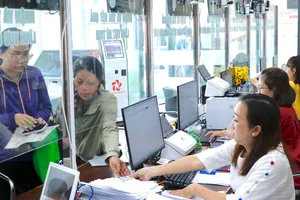 Công chức Trung tâm Phục vụ hành chính công xã Bà Điểm (một trong các xã đủ điều kiện thành lập đơn vị hành chính đô thị) hướng dẫn người dân thực hiện thủ tục hành chính. Ảnh: NGÔ BÌNH