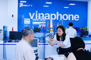 Nhân viên VinaPhone giúp khách hàng xác nhận sinh trắc học đăng ký thuê bao di động.