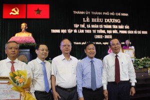 党中央政治局委员、市委书记阮文年（右一）祝贺获表彰者。