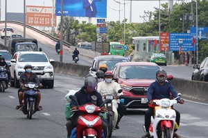 许多人在炎热的天气下骑摩托车返回本市复工。