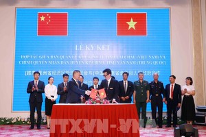 越南莱州经济区管委会主任武辉和与中国金平县委常委、副县长姚治明签署合作备忘录。 