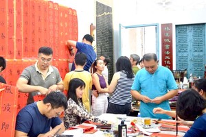 学员们将写好的春联张贴，充满浓浓春色。