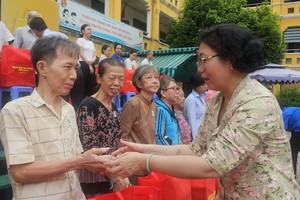 图：堤岸坊党部书记黄玉女芳红慰问华人同胞。