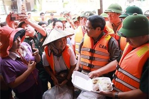 范明政总理慰问受洪灾影响民众。图自越通社 
