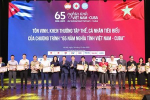 越南红十字会中央领导向对计划作出诸多贡献的集体和个人赠送鲜花和颁发奖状。