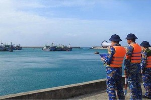 图: 战士们向民众宣传防范15号台风。