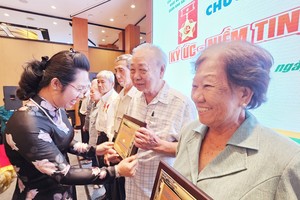 左关坊党委常务副书记胡氏竹江向华人革命有功者颁发徽章。