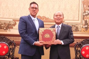 胡志明市人委会副主席陈文柒向印尼国会安全、国防、外交与情报委员会（第一委员会）副主席戴夫·阿克巴沙·菲卡诺·拉克索诺赠送纪念品。图：明珠