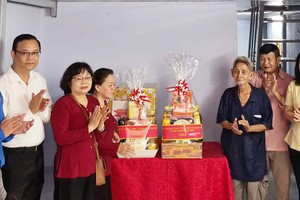市越南祖国阵线委员会副主席张氏碧幸与坊领导向华人贫困户移交温情屋。