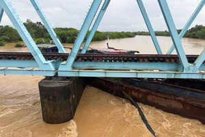 9 月 13 日，一艘驳船漂流并被困在广治省美政铁路桥桥墩处。照片: ĐỨC NGHĨA - VĂN THẮNG