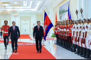 越南政府总理黎明兴与柬埔寨首相洪玛奈检阅柬军仪仗队。图自 越通社