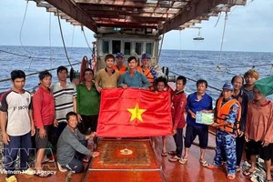 胡志明市海上执法力量向正在海上作业的渔民赠送国旗，并开展打击非法、不报告和不管制（IUU）捕捞行为的宣传活动。图片：越通社