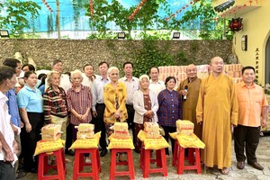 释慧功和尚和龙华寺护法会成员向贫困群众发送慈善礼物。