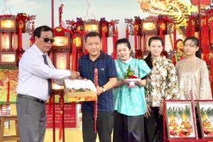 欧阳平理事长将“一帆风顺”圣灯移交给阮俊英家庭。