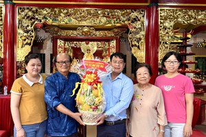《西贡解放报》华文电子版采编部主任文忠孝向温陵会馆理事长洪世真赠送果篮祝贺观音庙成道日。