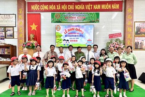 颍川双语学校励学会向一年级新生赠送安全帽和礼物。图：仁建