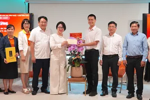 Đồng chí Nguyễn Việt Long (thứ 4 từ phải vào) trao quà của thành phố tới bác sĩ Phạm Thị Kim Loan. ẢNH QUANG HUY