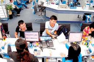Customers do transactions at a bank. (Photo: SGGP)