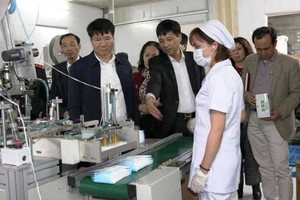 A delegation from the Ministry of Health visits a medical face mask manufacturer. (Photo: SGGP)