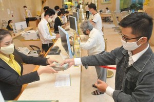 Customers do transactions at a commercial bank in Ho Chi Minh City. (Photo: SGGP)