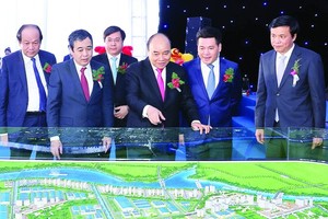 Prime Minister Nguyen Xuan Phuc and delegates watch the scale model of Lien Ha Thai Industrial Park - Thai Binh Economic Zone. (Photo: VNA)