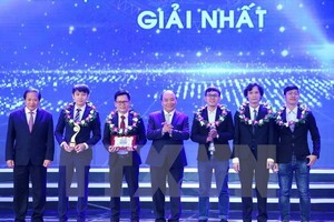 Prime Minister Nguyen Xuan Phuc (centre) and Minister of Information and Communications Truong Minh Tuan (first, left) present the first award in the field of IT (Photo: VNA)