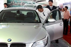 A visitor looks at a BMW model at an auto show in HCM City (Photo: VNA)