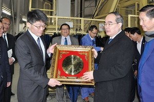 Secretary of HCMC Party Committee Nguyen Thien Nhan presents gifts to the Management Board of the Metropolitan Area Outer Underground Discharge Channel. (Photo: Sggp)