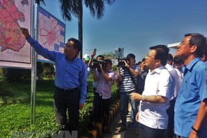 Deputy Prime Minister Trinh Dinh Dung (white shirt) and other officials listen to the introduction of Long Thanh project on April 12 (Photo: VNA)