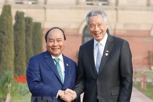 Prime Minister Nguyen Xuan Phuc (L) shakes hands with Singaporean PM Lee Hsien Loong (Photo: VNA)