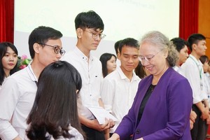 Chairperson of the Nguyen Van Huong scholarship fund council Dr. Truong Thi Xuan Lieu presents scholarships to students. (Photo: Sggp)