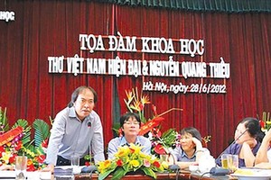 Poet Nguyen Quang Thieu (L) speaks at a seminar. (Photo: Sggp)