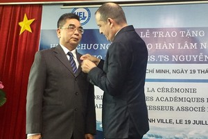 Consul General of France in HCM City Vincent Floreani presents Order of Academic Palms of France to Assoc. Prof. Dr. Nguyen Ngoc Dien. (Photo: Sggp)