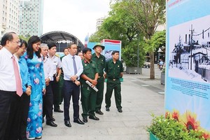 Deputy Secretary of the Party Committee of Ho Chi Minh City Tat Thanh Cang (L) attends the exhibition in Nguyen Hue walking street. (Photo: Sggp)
