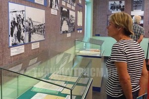 A foreign visitor contemplates pictures at the exhibition. (Photo: hcmcpv.org.vn)